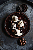 Schokoladentarte verziert mit Schokoeiern und schmelzendem Eis
