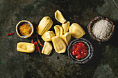 Ingredients for cooking vegan curry: Ripe raw peeled jackfruit with white uncooked rice, chopped tomatoes and spices