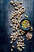 Pistachios and nutshells over black wooden background