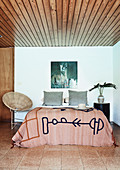Tagesdecke im Ethno-Stil auf dem Bett im Schlafzimmer in Erdfarben