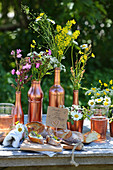 Baguette with floral butter on table decorated with wildflowers in copper-coloured containers