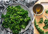 Preparation of kale salad with leaves broken up and coated in dressing