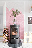 Dekorativer Schwedenofen vor rosa-weißer Wand