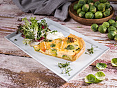Brussels sprouts and apple quiche with lettuce, cress and sour cream