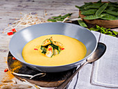 Zucchini curry cream soup with chili, bean sprouts and mangetouts
