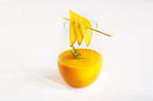 Mango-Karotten-Smoothie mit Mangoscheiben und Möhrengrün