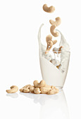 Cashew kernels falling into milk