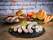 Fresh beef bratwurst in natural gut casing, with vegetables, bread and mustard