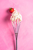 Whisk with whipped cream and strawberry