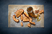 Toasted bread on baking paper with a bottle of herb olive oil
