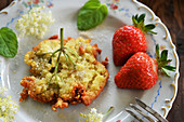 Elderflowers in pancake batter with fresh strawberries and sugar