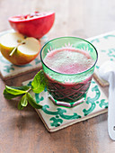 An apple and pomegranate smoothie with mint