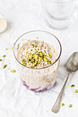 Chia pudding with blueberry compote and pistachios in a glass