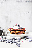 A stack of pumpkin waffle with blueberries and yoghurt