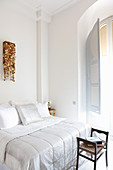 Light-flooded bedroom with stucco ceiling and arched window