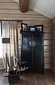 Black Chinese cabinet in rustic wooden house