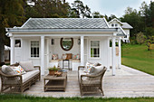 Terrasse mit Rattanmöbeln vorm Gartenhaus im viktorianischen Stil