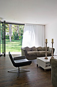 Simple living room with open terrace doors leading into garden