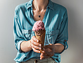 Hand holding ice cream in cone