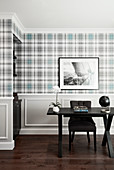 Desk in front of wall with tartan wallpaper and panelled wainscoting