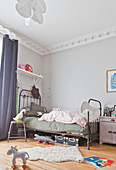 Vintage metal bed in child's bedroom with stucco ceiling frieze