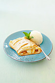 Apple strudel made from puff pastry with vanilla ice cream from a tin