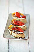 Bruschetta with grilled vegetables and cream cheese on a tray