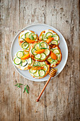 Small tarte flambées with goat's cream cheese, zucchini, apricots and honey on a tray