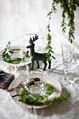 Place settings decorated with larch twig on table set for Christmas meal