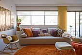 Sofa and classic chair in living room with orange accents