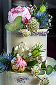 Dreistöckige Hochzeitstorte mit Schokoladenböden, Vanillebuttercreme, Himbeerfüllung und Blumendeko
