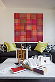 Pixellated artwork in shades of red above sofa