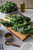 Kale on a kitchen board and mustard seeds in a tin can