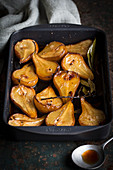 Baked pears with bay leaves in a baking dish