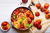 Spaghetti alla bolognese in der Pfanne mit Ofentomaten und Basilikum