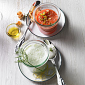 Geeiste Tomatensuppe mit Gemüsewürfel und Gurken-Schaumsuppe in Gläsern