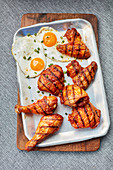 Marinated, grilled chicken bits with fried eggs