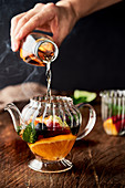 Heißer Tee mit Früchten in Glaskanne