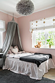 Bett mit Volant und Baldachin im Mädchenzimmer in Rosa und Grau