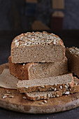 Gluten-free bread with sunflower seeds on a round wooden board