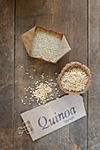 Quinoa, whole and puffed, with a label on a wooden table