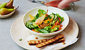 Fruity summer salad with vegetables, pears and wholemeal baguette slices