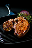 Fried pork chop with red onions, garlic and rosemary