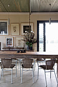 Rustic wooden dining table, rattan chairs and wrought-iron chandelier