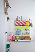 Shelves with brightly coloured back wall in child's bedroom