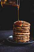Drizzling hot cross bun pancakes with honey