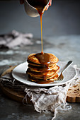 Pancakes being drizzled with caramel sauce