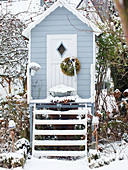 Stilt house in snowy winter garden