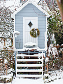 Baumhaus mit Schnee im Wintergarten