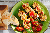Grilled, marinated chicken skewers with a cherry tomato sauce and basil